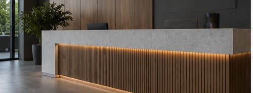 Commercial reception counter with a fluted timber front, warm strip lighting and a stone top